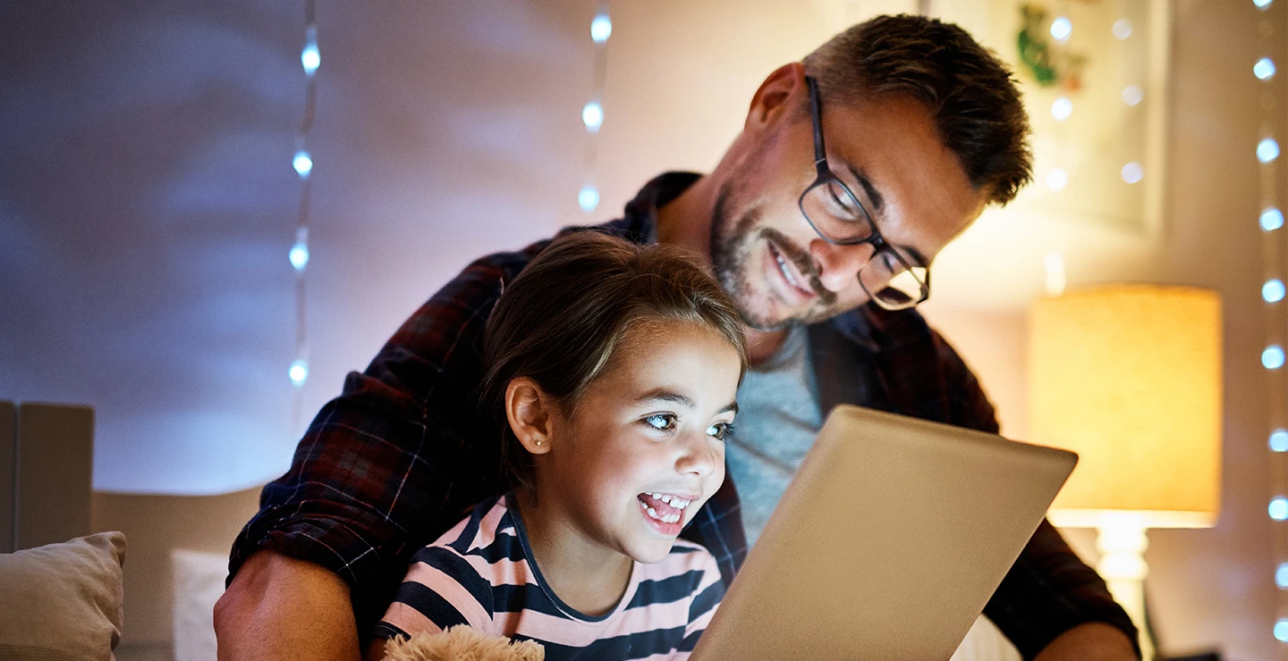 Dad reading a bedtime story to his daughter, so she can get a restful sleep