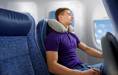 Young man sleeping on a plane to avoid jet lag. 